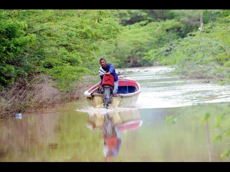 A man makes his way down a flooded street in Milk River in 2009.