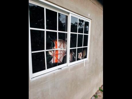 Two of the damaged windows at the home of selector Fyah Ras.