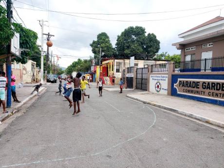 Youngsters enjoy a game of basketball on the streets of Parade Gardens in downtown Kingston.