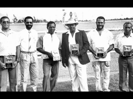 MILLION-DOLLAR MILESTONES: Caymanas Track Limited’s  Racing Secretary, Haleem Phillipps (2nd left) presented commemorative plaques to five Caymanas Park trainers who attained million-dollar career milestones in 1991. They are (from left) Godwin “Bunny” Bucknor, Charles Morrissey (third left), Enos Brown, Richard Todd and Sydney Watson. 