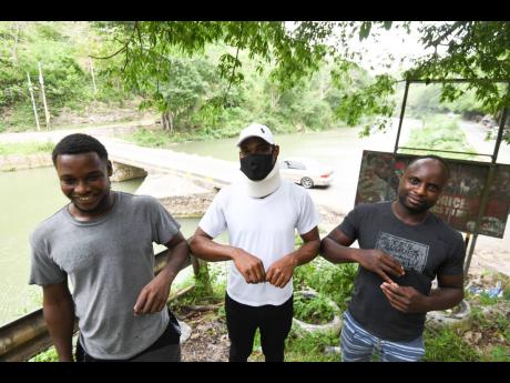 Divers Dwayne ‘Lizard’ Stapelton (left) and Rosaine ‘Chupsy’ McLaughin (right) are flanked by Jermaine Scott who they saved from drowning on May 8.