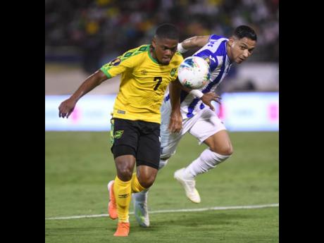 Jamaica’s Leon Bailey (left) gets to the ball before Honduran defender Emilio Izaguirre during a CONCACAF Gold Cup encounter at the National Stadium in 2019.