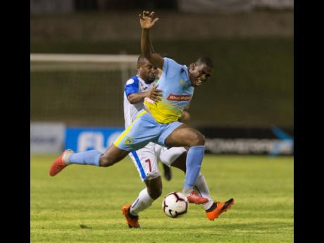 In this file photo from May 2019, Keithy Simpson (front), then of Waterhouse FC, is tackled by Portmore United’s Damian Williams during a FLOW Concacaf Caribbean Club Championship match at the National Stadium in Kingston.