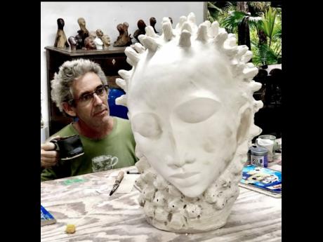 Credit: Contributed Pinto pays keen attention to a sculpture.