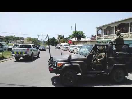 Police and military personnel at a checkpoint yesterday in Norwood, St James.