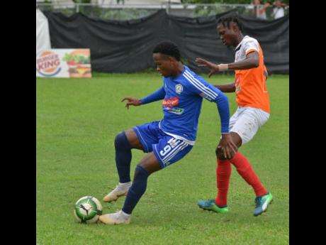 Mount Pleasant’s Kemar Beckford (left) shielding the ball from Adrian Williams of Dumbeholden during a Jamaica Premier League match on Wednesday, January 16, 2019. 