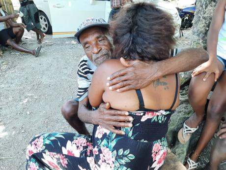 Rupert Wachope comforts one of his nieces, Keisha Silvera, as she tries to come to terms with the passing of her father, Leric Silvera. 