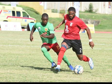 Oneil Anderson (right) of Arnett Gardens getting the better of Humble Lion’s Lorenzo Lewin during a Jamaica Premier League match played on Monday at the Stadium East field. Arnett Gardens won 2-1. 