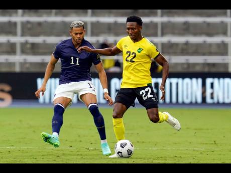 Jamaica’s midfielder Devon Williams (right) moves the ball past Costa Rica forward Ariel Lassiter (11) during the first half of last night’s Concacaf Gold Cup Group C  match in Orlando, Florida.