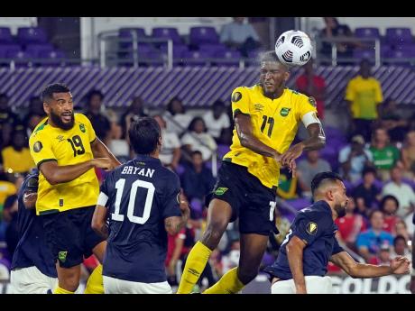 Jamaica’s Damion Lowe (right) heads the ball towards goal in front of Costa Rica midfielder Bryan Ruiz (10) and defender Giancarlo Gonzalez (right) during last night’s Concacaf Gold Cup Group C match in Orlando, Florida. At left is Jamaica’s defender Adrian Mariappa. 