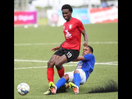 Arnett Gardens player Luca King (left) is on the end of a sliding tackle from Mount Pleasant’s Sue-Lae McAlla during Sunday’s Jamaica Premier League match at the UWI/Captain Horace Burrell Centre of Excellence.