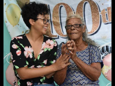 
Inez Jones enjoys the company of 
her great-granddaughter, Sachia Chin 
Loy, at her 100th birthday celebration on July 18.