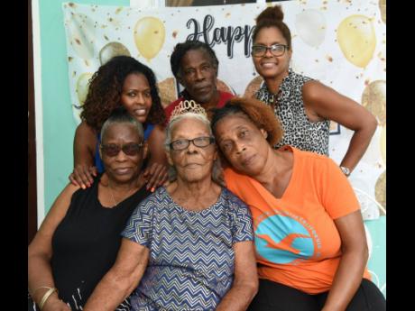 Inez  Jones (centre, seated), who celebrated her 100th birthday on July 18, is surrounded by family members. From left: Daughter Iona Jones, granddaughter Celia Rowe, son Kenneth Jones, daughter Maureen Jones, and granddaughter Stacy Bennett.