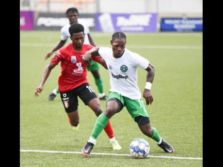 Credit: Ricardo Makyn Vere United FC’s Ramone Plummer maintains possession of the ball from Arnett Gardens FC’s Rushike Kelson during the Jamaica Premier League football match at the UWI/JFF Captain Horace Burrell Centre of Excellence yesterday. Vere won 1-0.