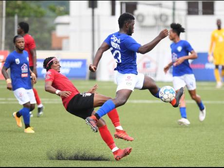 Mount Pleasant’s Prince Christie (right) tries to evade a tackle from Arnett Gardens’ Steve Clarke during their Jamaica Premier League game at the UWI/JFF Captain Horace Burrell Centre of Excellence on Sunday, July 25.