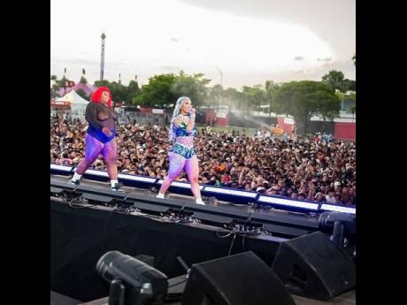 DHQ Famous Red (left) walks out with Shenseea during her performance at Rolling Loud.