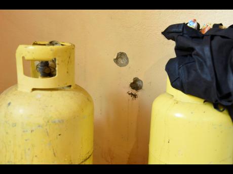 Bullet holes in the kitchen show how close the shots came to hitting these cylinders.