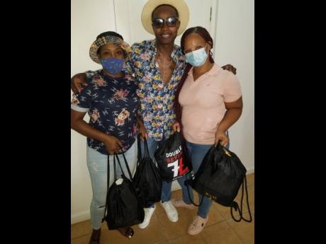 Dancehall artiste Razor B (centre) with two of the recipients. 