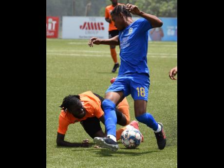 Devroy Grey (left) of Tivoli Gardens goes down after a tackle by Oniel Small (right) of Molynes United during their Jamaica Premier League match at the UWI-JFF Captain Horace Burrell Centre of Excellence last Saturday. The match ended 1-1.