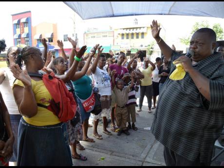 In this 2014 photo, Bishop Maurice Perrier, head of Fire Anointed Healing and Deliverance Ministries, preaches the gospel on the streets of downtown Kingston.