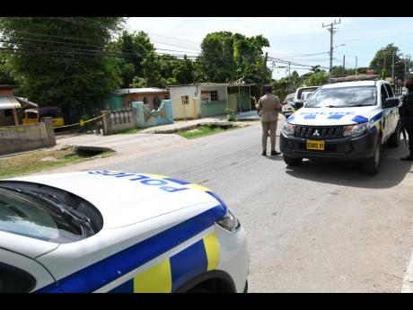 Police outside the crime scene in Gregory Park, St Catherine.