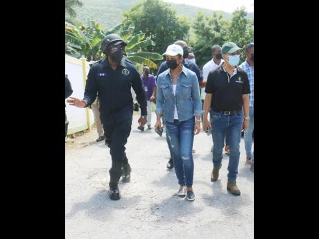 Senior Superintendent of Police Vernon Ellis (left), Member of Parliament of St James West Central Marlene Malahoo Forte  (centre) and Dr Horace Chang, the minister of national security, tour a section of Granville, St James following Sunday morning’s bloody attack.
