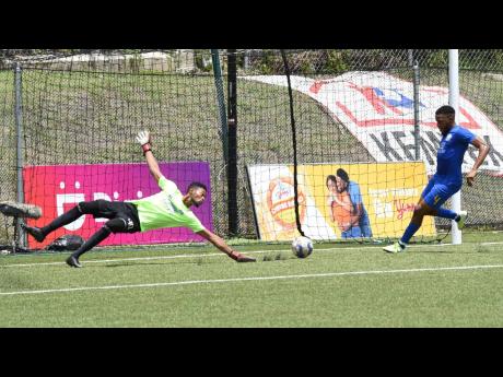  Molynes United’s Ackeem Stewart (right) clears the ball off the line after goalkeeper Leon Taylor was beaten during their preliminary round Jamaica  Premier League football match against Tivoli Gardens on September 11. The game ended 1-1.