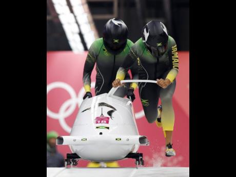 Credit: File File photo shows driver Jazmine Fenlator-Victorian (right) and Carrie Russell of Jamaica start their first heat during the women’s two-man bobsled competition at the 2018 Winter Olympics in Pyeongchang, South Korea. Russell is hoping a foot injury heals in time for her to resume competition for a Jamaica spot at the Beijing Winter Olympics next February.