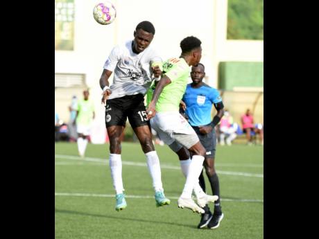 Andre Fletcher (right) of Waterhouse FC is beaten to the ball by Cavalier’s Kyle Ming during the Jamaica Premier League final at the UWI-JFF-Captain Horace Burrell Centre of Excellence last  Saturday.  The match ended 1-1 after extra and regulation time and was decided by penalties with Cavalier winning 5-4.