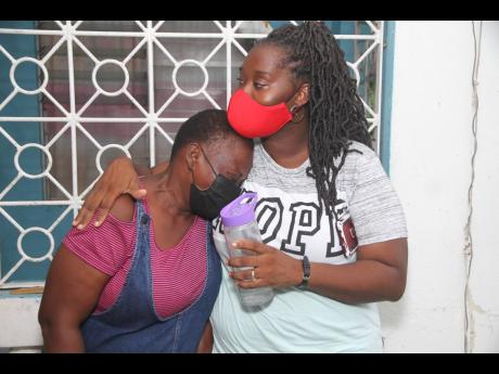 Lisa Swaby (right), of Race Course Clarendon, comforts her mother, Althea Donaldson, as they grapple with the death of matriarch Hazel Beckford, who died days after the ambulance  she was being transported in was involved in a crash.