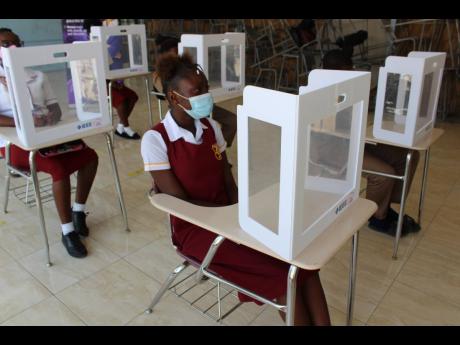 Students of Denham Town High School in Kingston sit at their desks, which were outfitted with desk shields, following the brief reopening of schools to face-to-face learning last year.