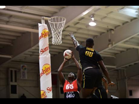 Jamaica Men’s player Kyle Foster defends against Afeisha Noel of Trinidad and Tobago  during the Sunshine Series Invitational exhibition netball match  at the National Indoor Sports Centre in St Andrew last night.