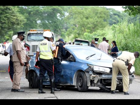 Credit: Kenyon Hemans Investigators look at the unmarked vehicle that was being used to transport Pastor Kevin O. Smith from Montego Bay, St James, to Kingston where detectives were waiting to charge him for his role in the alleged human sacrifice at his church two Sundays ago.