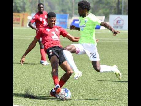 Colorado Murray (right) of Waterhouse evades a  tackle from Earl Simpson of  Arnett Gardens during their Jamaica Premier League match at the UWI-JFF Captain Horace Burrell Centre of Excellence in September. Waterhouse won the game 4-1.