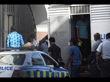 Alleged members of the One Don Gang arrive at the Home Circuit Court in downtown Kingston yesterday as their trial continues.