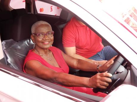 Daphne Francis appears comfortable behind the wheel of the 2021 Mitsubishi Outlander she won in the Scotiabank Mastercard Debit Card Activation competition.