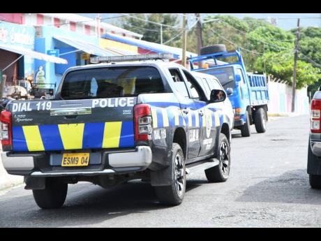 Police patrol a section of Franklyn Town in Kingston during a 48-hour curfew that was imposed in the community in the Kingston East division.