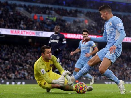 West Ham’s goalkeeper Lukasz Fabianski (left) makes a save in front of Manchester City’s Joao Cancelo during the English Premier League match between Manchester City and West Ham United at the Etihad stadium in Manchester, England, yesterday.