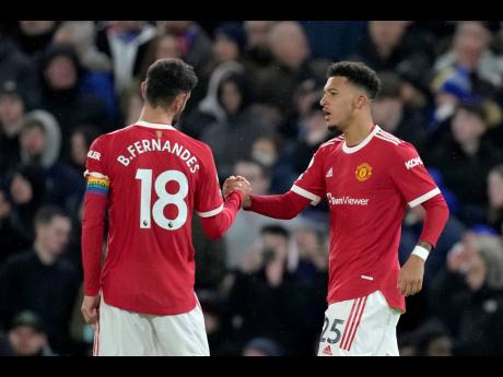 Manchester United’s Jadon Sancho (right) celebrates with Bruno Fernandes after scoring the opening goal during the English Premier League match between Chelsea and Manchester United at Stamford Bridge stadium in London yesterday. The game ended in a 1-1 draw.
