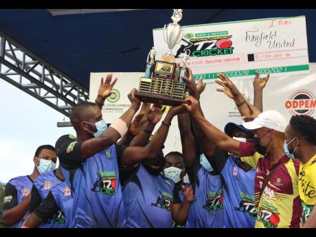 Fairfield United’s players lift the SDC trophy after beating Race Course in the final at Noranda Cricket Ground in Discovery Bay, St Ann yesterday.