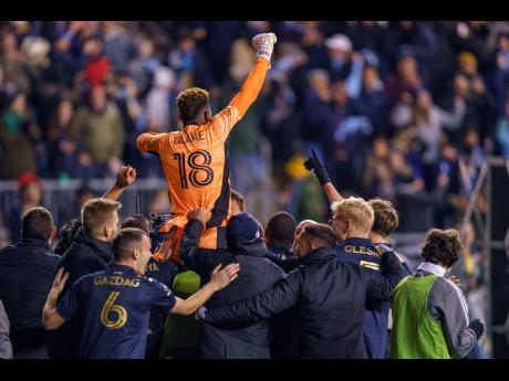 Philadelphia Union’s Andre Blake (18) is lifted by teammates following last night’s penalty shoot-out in the MLS play-off match against Nashville SC in Chester, Pennsylvania. 