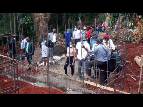Local Government Minister Desmond McKenzie (right) and other officials on the site where the home for the Westmoreland family is being constructed. McKenzie had hoped for the family to be able to move in by Christmas, but that will not happen.