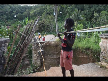 Residents of Troy use a makeshift pulley to transport goods across the span where the bridge once stood.