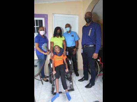 Jodeon Davis-Lawrence (standing, second left) and her son, Nickardo King (in wheelchair), with (from left) Tracy-Ann James, Desmond Reid and Lloyd Richardson.