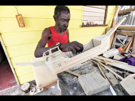 Credit: Rudolph Brown Alvin Lewis works on a miniature ship in his home community of Majesty Gardens, St Andrew, yesterday.