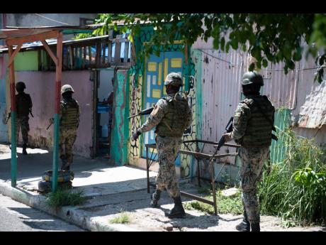 Credit: FILE Members of the Jamaica Defence Force on patrol in Parade Gardens during a curfew.