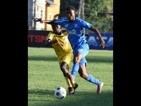 Clarendon College's Christopher Hull (right) moves past Charlie Smith's Christopher Wilson during their ISSA Champions Cup game at Stadium East in Kingston on Wednesday.