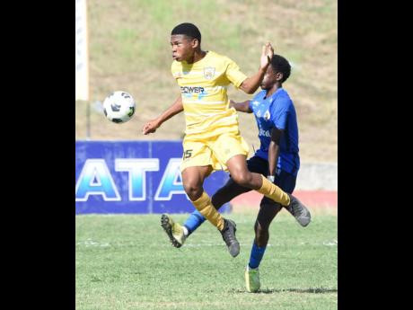 
Garvey Maceo High’s Shaquille Blackstock (left) in action against Dyllan John of Jamaica College during last Wednesday’s  Champions Cup quarter-final match at the Stadium East field.