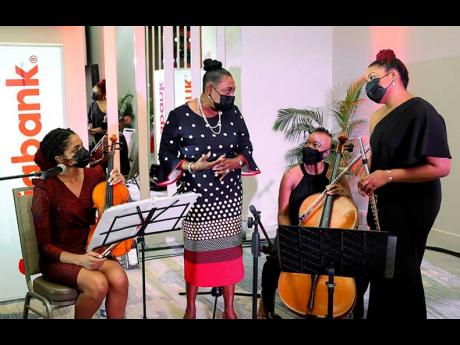 Olivia ‘Babsy’ Grange (second left), minister of culture, gender and entertainment, chats with members of the Practical Trio (from left), Truddi Clarke, Emily Ruth, and Gabrielle Clarke, who performed an inspired set during the launch of the Scotiabank Women Initiative earlier this week.