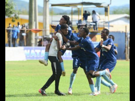 Manning’s High School goalkeeper Mikhail Romans (left) is swarmed by his teammates after defeating Dinthill Technical High School in a penalty shootout in a semi-final of the ISSA daCosta Cup at the STETHS Sports Complex in Santa Cruz, St Elizabeth, yesterday.